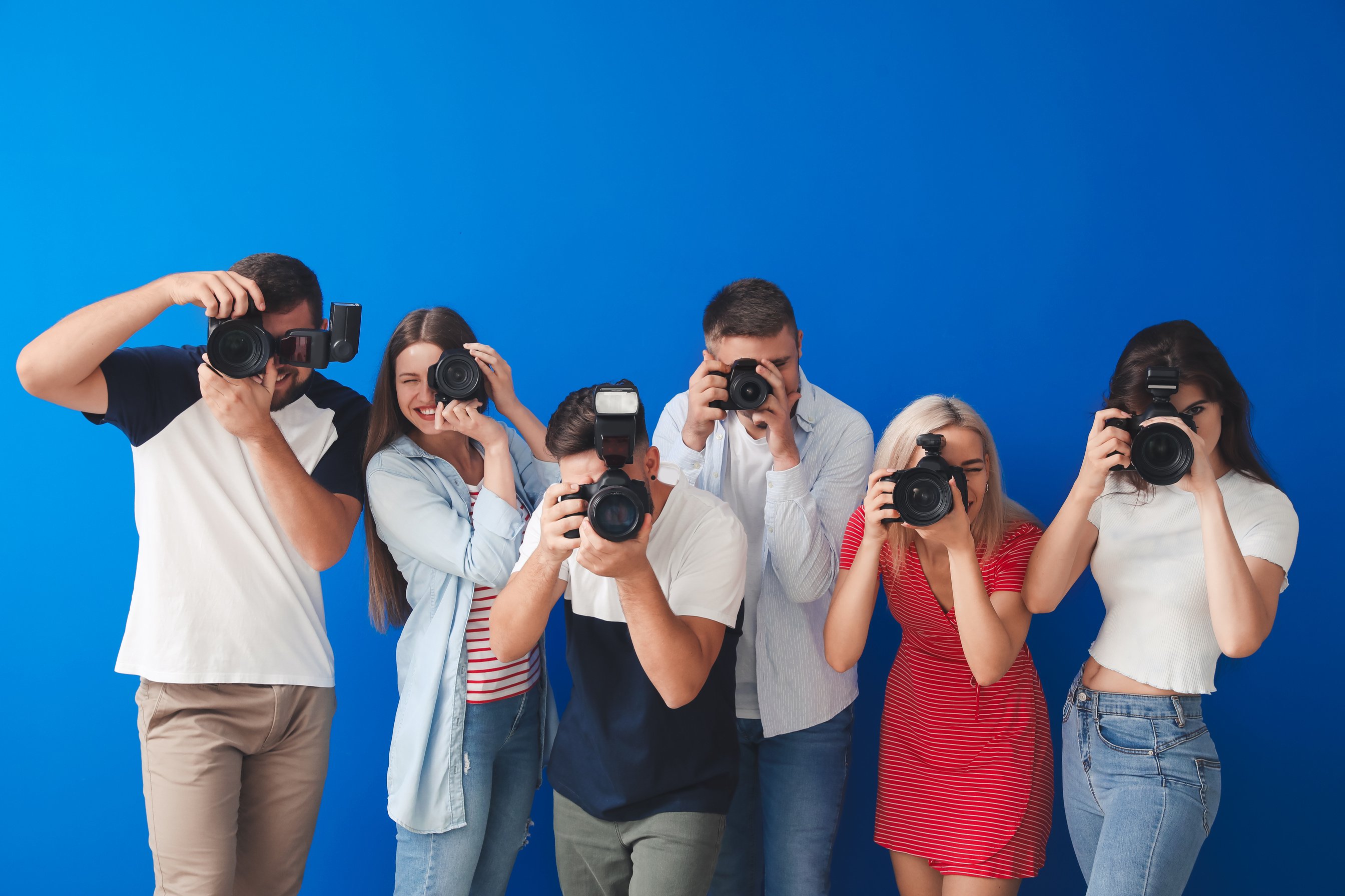 Group of Young Photographers on Color Background